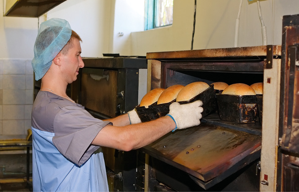 Печь хлеб в форме. Выпечка хлеба на хлебозаводе. Пекари пекут хлеб. Печь для хлеба производственная. Печь на хлебокомбинате.